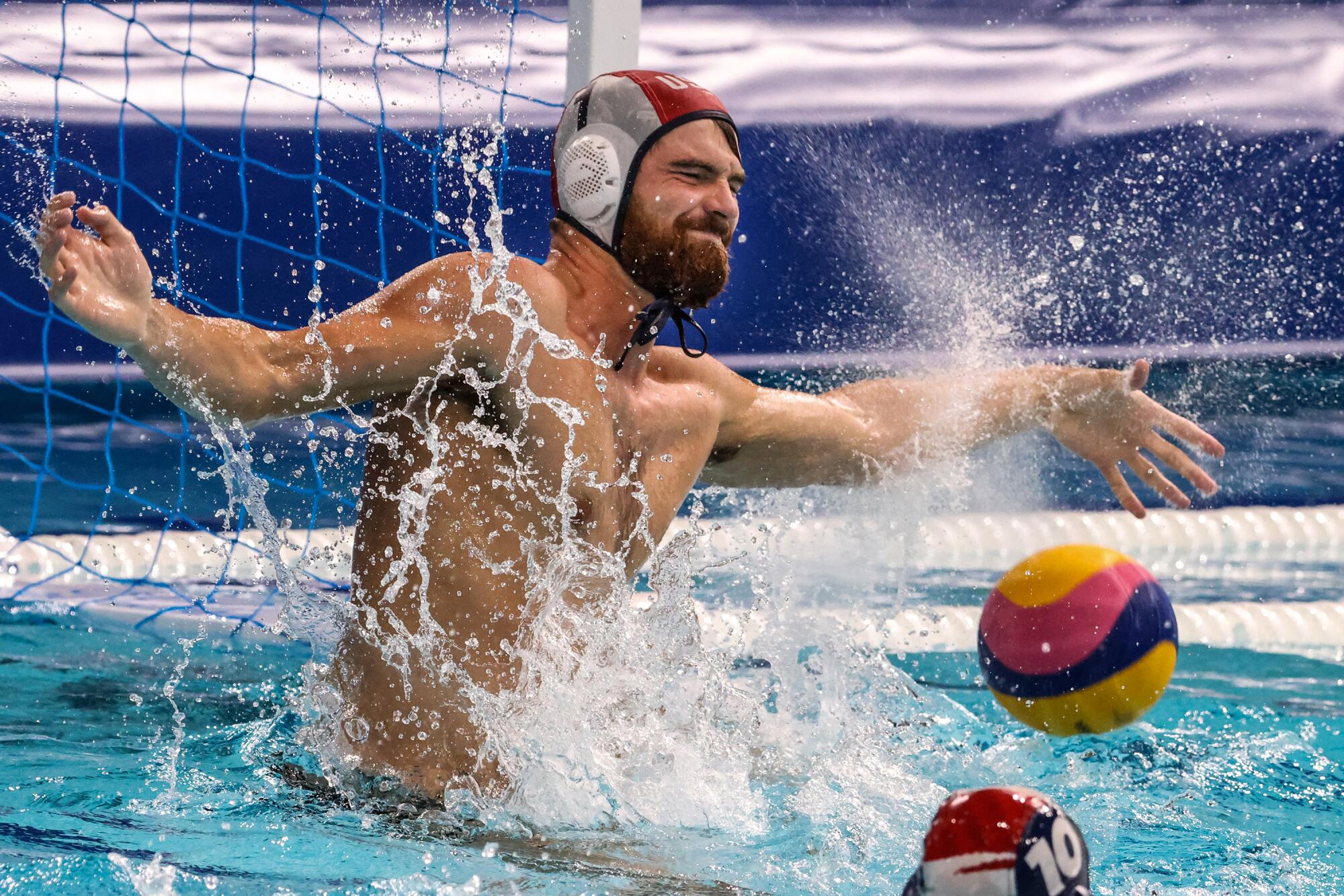 Goalkeeper Alex Wolf deflects the ball for the U.S. during water polo at the Tokyo Olympics.
