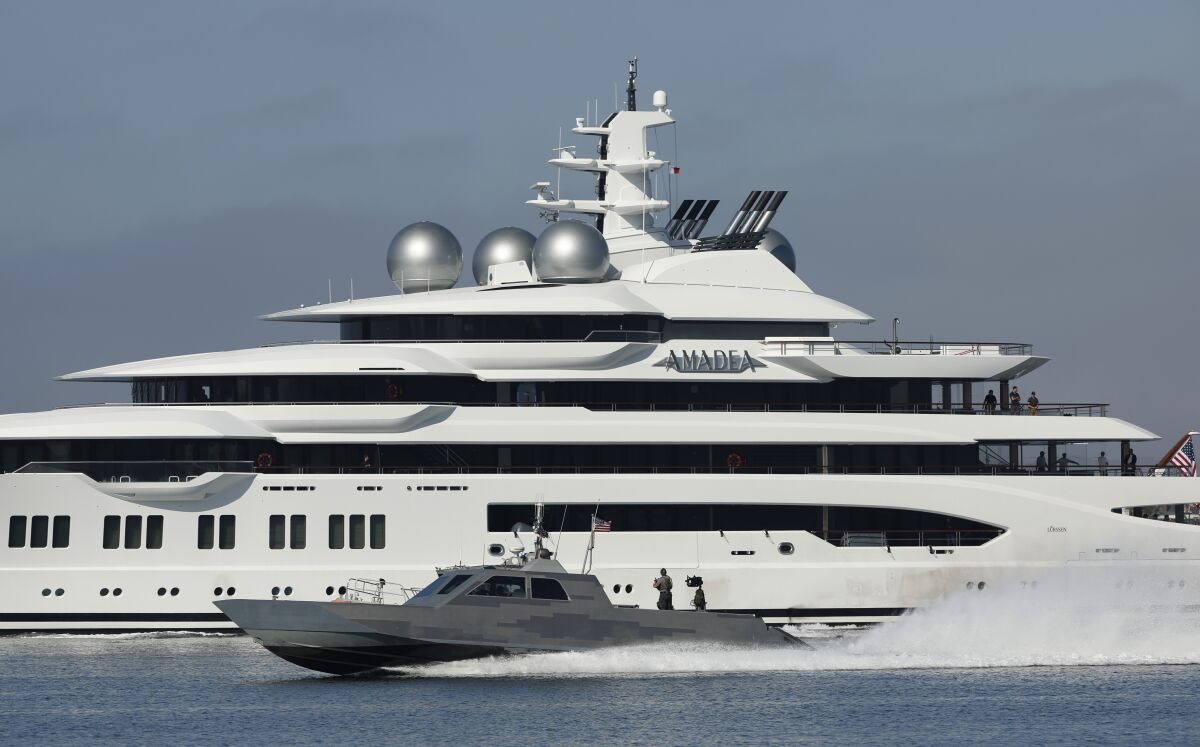 Navy boat speeds by the superyacht Amadea in San Diego Bay on  June 27, 2022