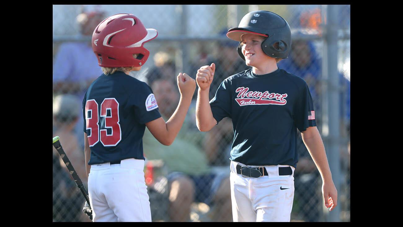 Newport Harbor Pony Bronco 11U player #33 Lawson Olmstead, left, congratulates #6 Bode Stefano after Stefano scored a run in game vs. Valley Wide, at York Field in Whittier, on Friday, July 13, 2018.