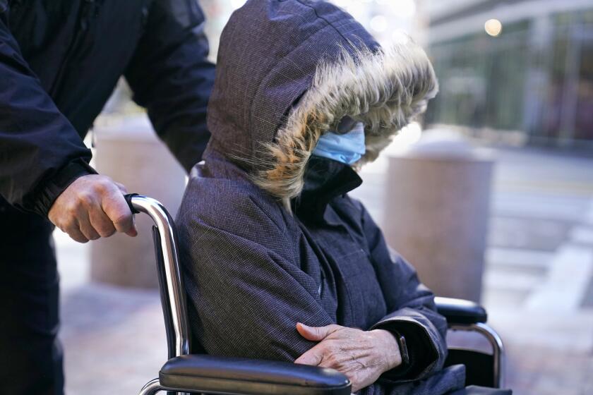 Elisabeth Kimmel, of La Jolla, Calif., is wheeled into federal court for a sentencing hearing, Thursday, Dec. 9, 2021, in Boston. Kimmel, a former chief executive of a media company who authorities say paid more than $500,000 to get her two children into elite universities as bogus athletic recruits, plead guilty during August 2021 to charges of conspiracy to commit mail and wire fraud. (AP Photo/Charles Krupa)