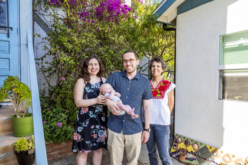 Nadine Levyfield, Charlie Marshak (holding baby Lev Marshak) and Mona Field (grandma) stand in front of their home.