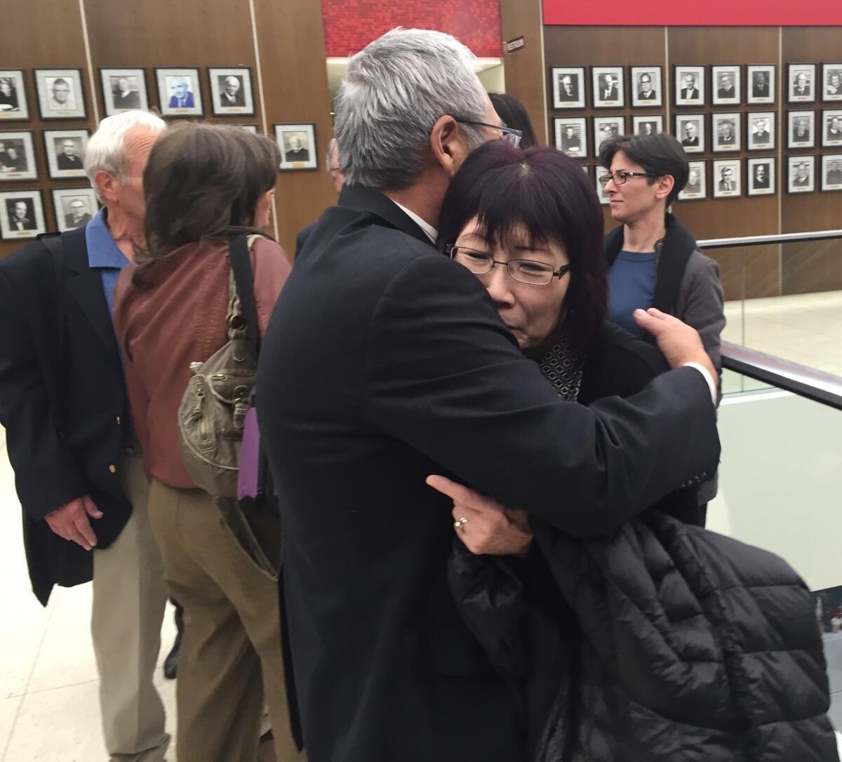 Masa and June Kibuishi embrace outside an Orange County courtroom Monday after a jury recommended the death penalty for the man convicted of murdering their 23-year-old daughter, Juri “Julie” Kibuishi, in May 2010.