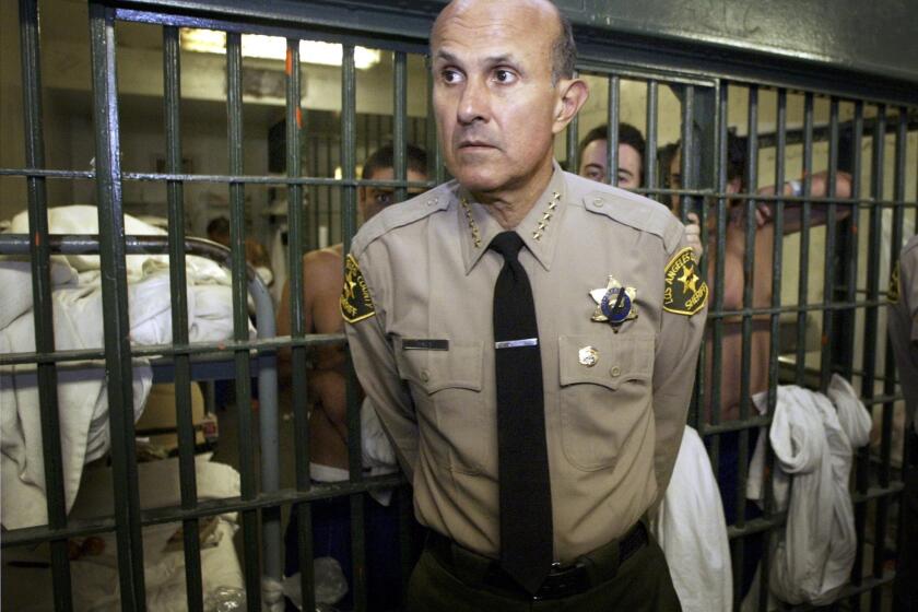 Former Los Angeles County Sheriff Lee Baca talks with members of the media as he leads a tour inside the Men's Central Jail at the Twin Towers Correctional Facility in Los Angeles in 2004.