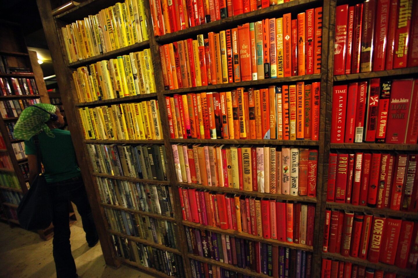A visitor walks past the "color installation." Brady Westwater, a volunteer at the Last Bookstore, created the installation by placing books containing red, yellow and green book jacket covers together.