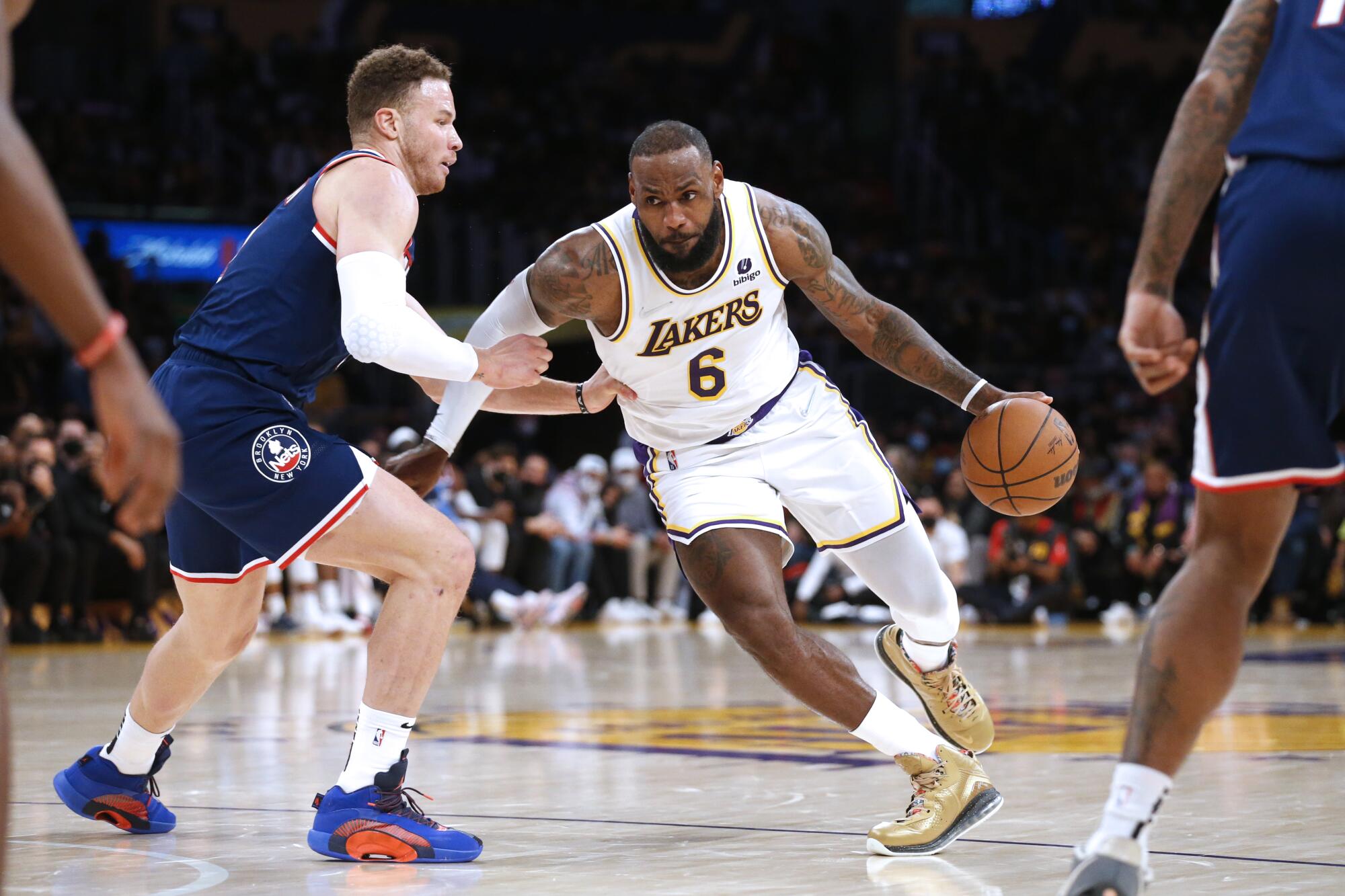 Lakers forward LeBron James, right, tries to drive past Brooklyn Nets forward Blake Griffin in the first half.