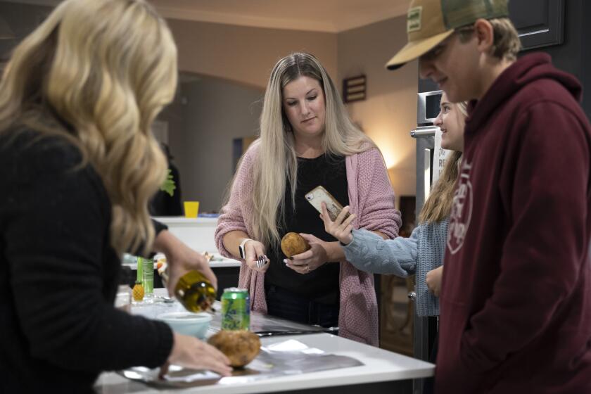 ROCKWALL, TEXAS OCTOBER 29, 2023 - Jennifer Balek, 39, center, stands in her kitchen preparing dinner while speaking to her mother Tina Bailey, left, her daughter Hannah Kight, 12, right, and son Zach Kight, 15, far-right, on Sunday, Oct. 29, 2023 in Rockwall, Texas. Like many Californians, insurance broker Jennifer Balek took advantage of pandemic-induced opportunities to work from home by moving to another state. The 38-year-old Camarillo native settled in Rockwall, a small community outside Dallas, where she and her husband bought a house big enough for their family of eight that they could never afford in Southern California. She also knew Texas has no state income tax. Gas for their vehicles is a lot cheaper. What Balek did not realize, however, was just how drastically different the state laws and regulations are on employment and related issues. And those unrecognized differences can turn out to matter. Balek still works for the same California employer of nearly 20 years, but by moving her residence to another state, she faces the possibility of losing or getting significantly diminished benefits and protections. California is one of the most progressive when it comes to employee rights.