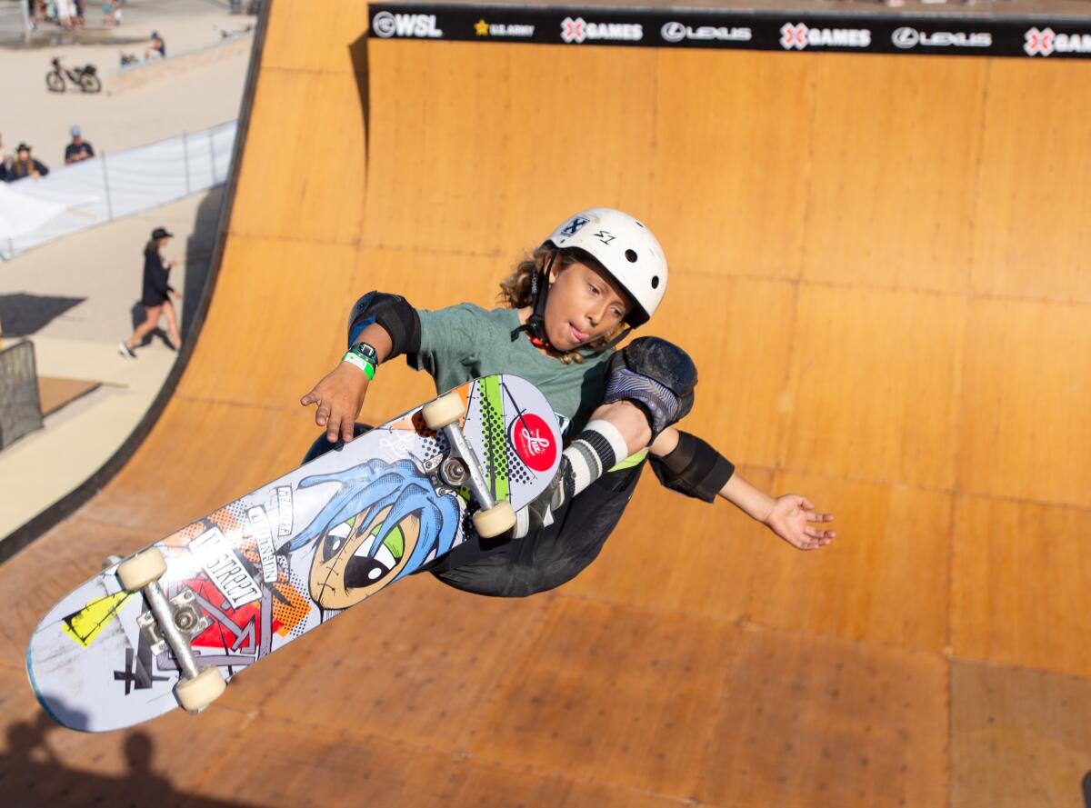 Valen Meyer sticks his tongue out while launching off of a vert ramp built on the sand just south of Huntington Beach Pier