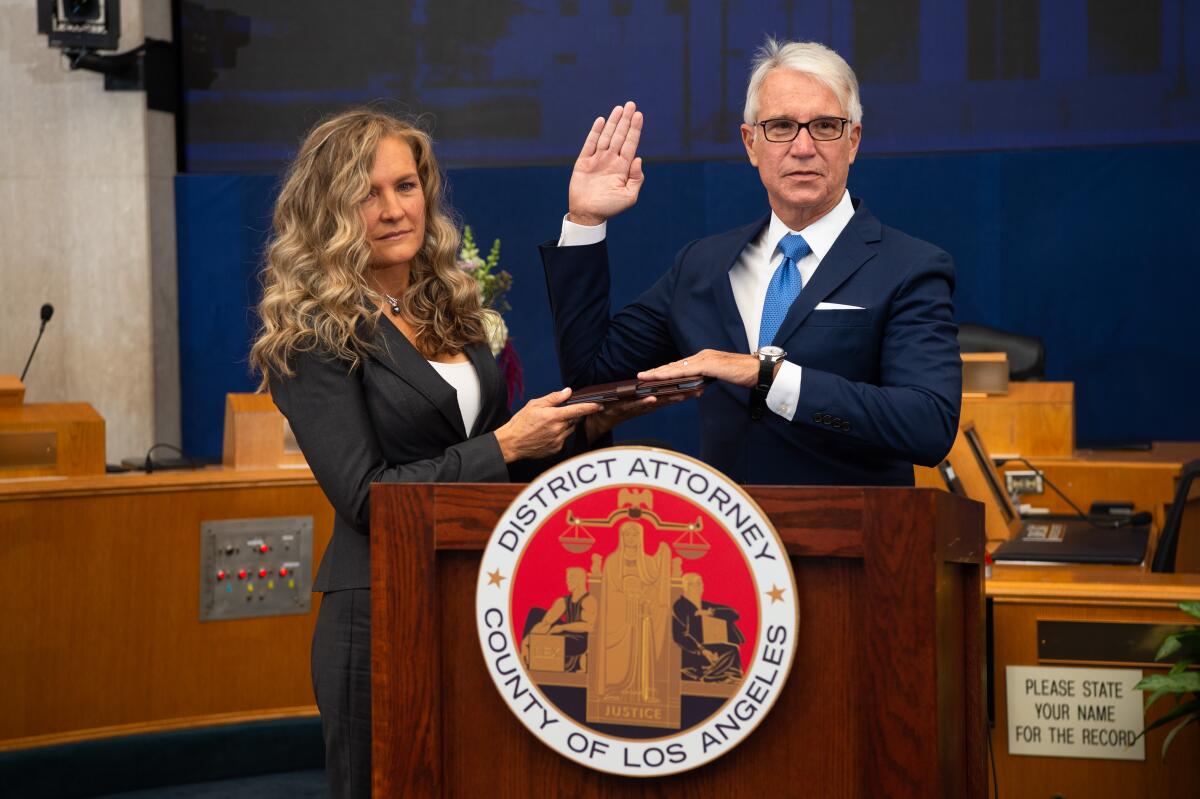 L.A. County Dist. Atty. George Gascón takes the oath of office as his wife Fabiola Kramsky holds a copy of the Constitution