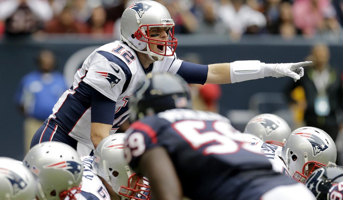 New England quarterback Tom Brady (12) calls signals at the line of scrimmage while running a no-huddle offense against the Houston Texans during a game last season.