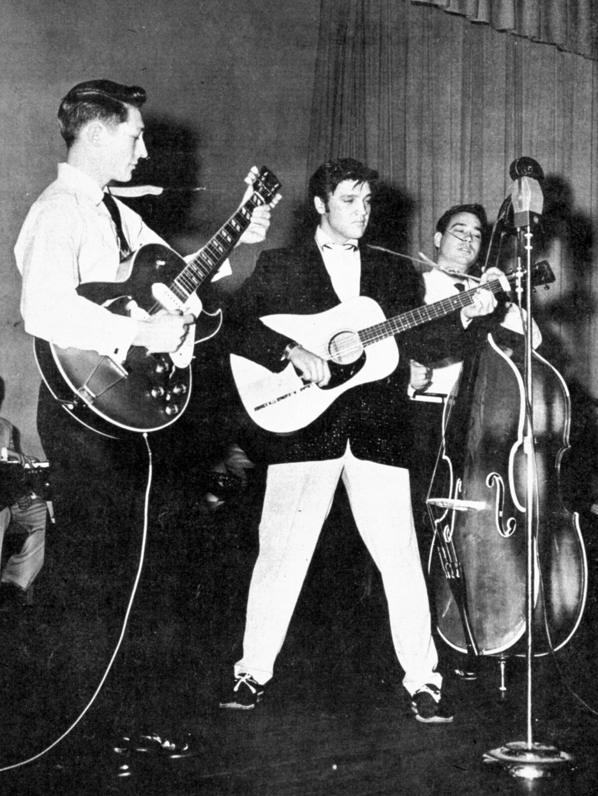 Elvis Presley performs in the summer of 1957, with Scotty Moore on guitar to his left. (Associated Press)