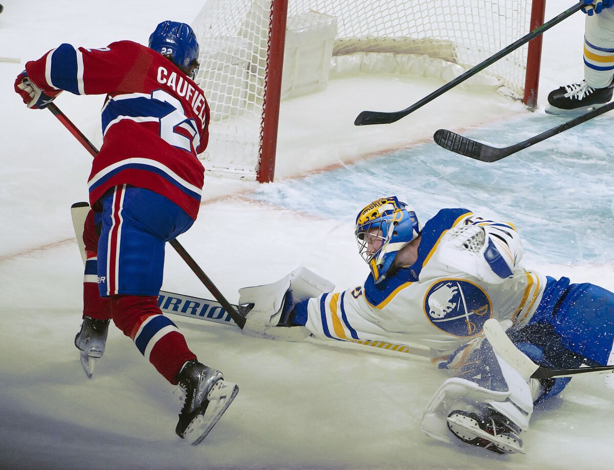 Buffalo Sabres goalie Craig Anderson stops a shot from Montreal Canadiens right wing Cole Caufield (22) during the first period of an NHL hockey game Wednesday, Feb. 23, 2022, in Montreal. (Peter McCabe/The Canadian Press via AP)