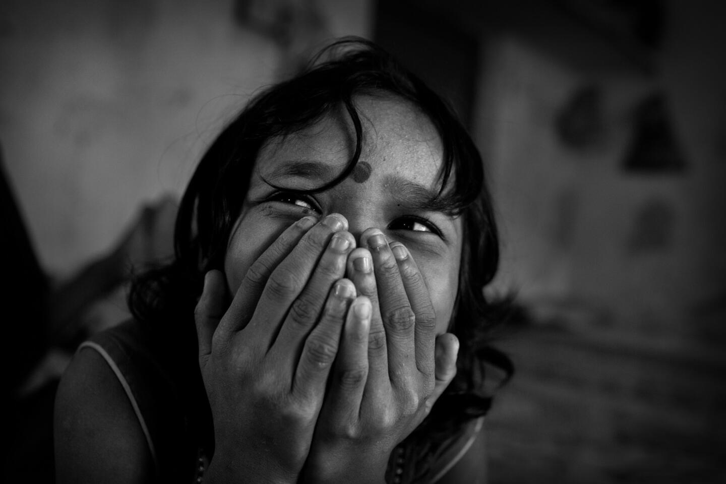 Twelve-year-old Karishma enjoys a shy moment laughing with her friends inside the boarding school, where she lives with some other 100 girls.