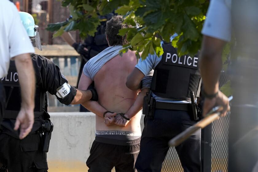 Police take a protester into custody after a fence surrounding United Center was knock down at the Democratic National Convention Monday, Aug. 19, 2024, in Chicago. (AP Photo/Alex Brandon)