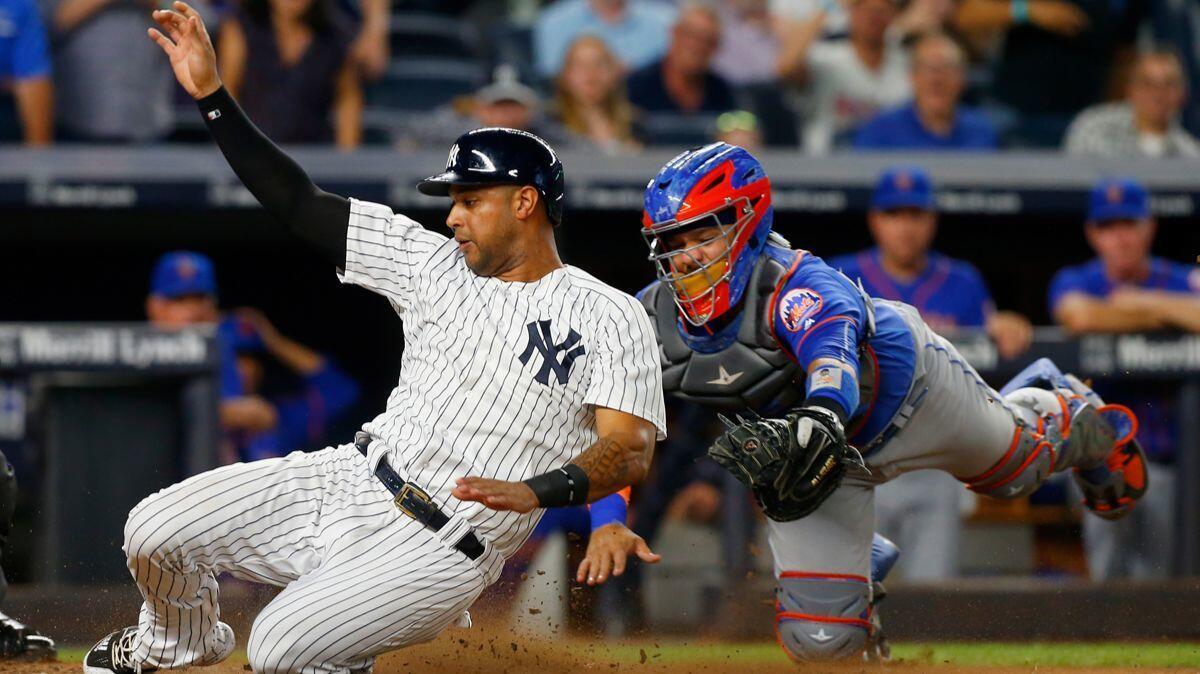 New York Yankees' Aaron Hicks (31) beats the tag from New York Mets' Rene Rivera (44) to score a run in the fourth inning at Yankee Stadium on Aug. 14, 2017.
