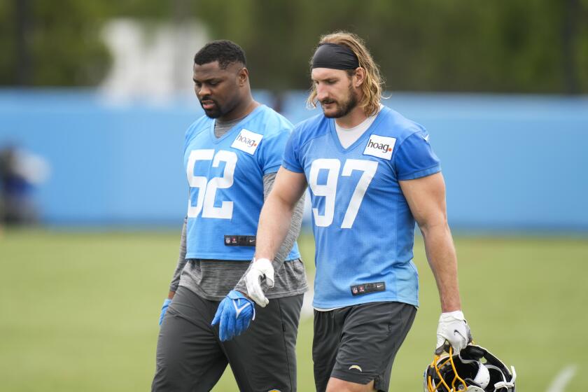 Los Angeles Chargers linebacker Joey Bosa (97) walks with linebacker Khalil Mack (52) during the NFL football team's camp Wednesday, May 31, 2023, in Costa Mesa, Calif. (AP Photo/Jae C. Hong)