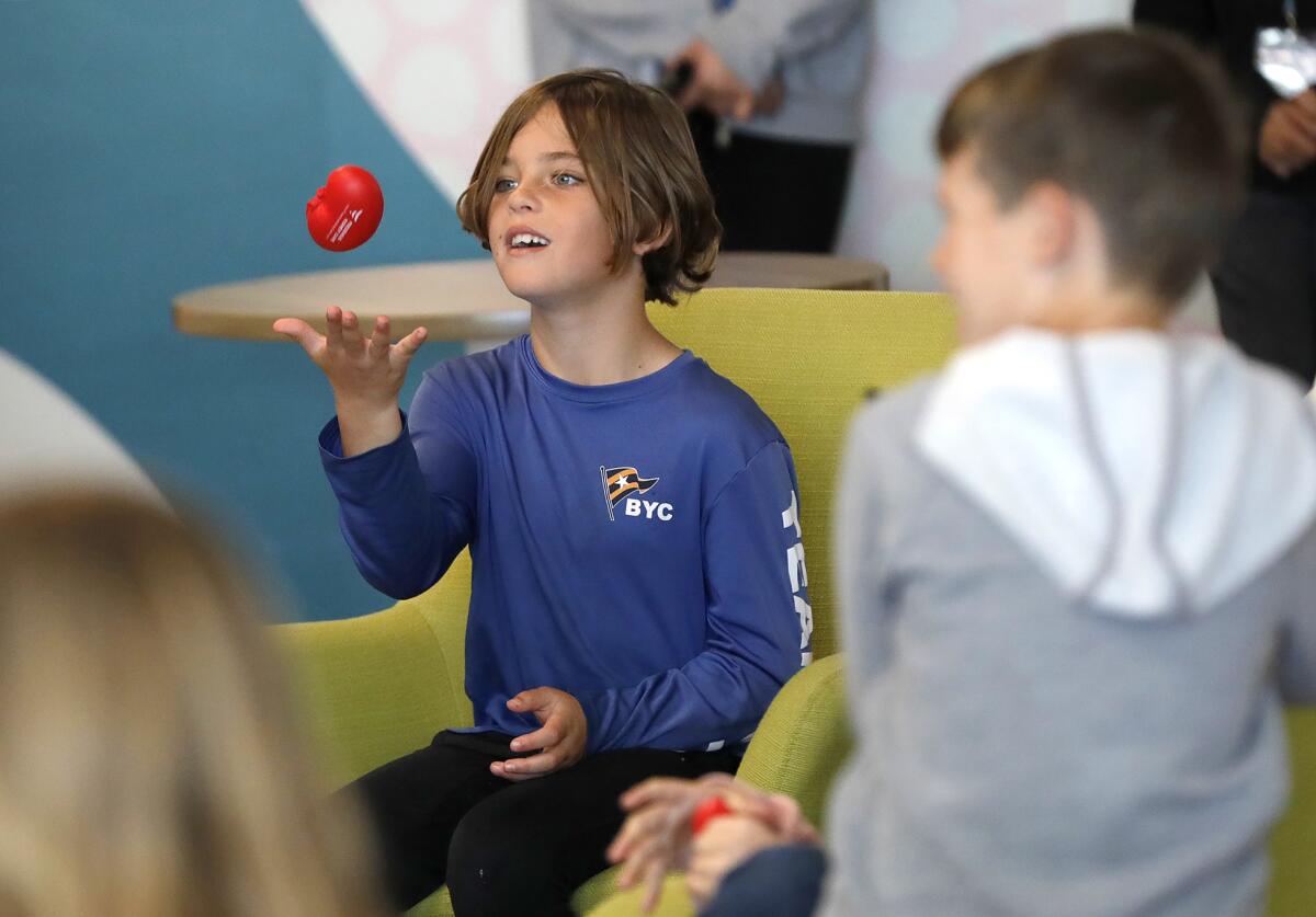A youngster plays catch with a toy kidney he won while listening to educational event by Fresenius Kidney Care volunteers.
