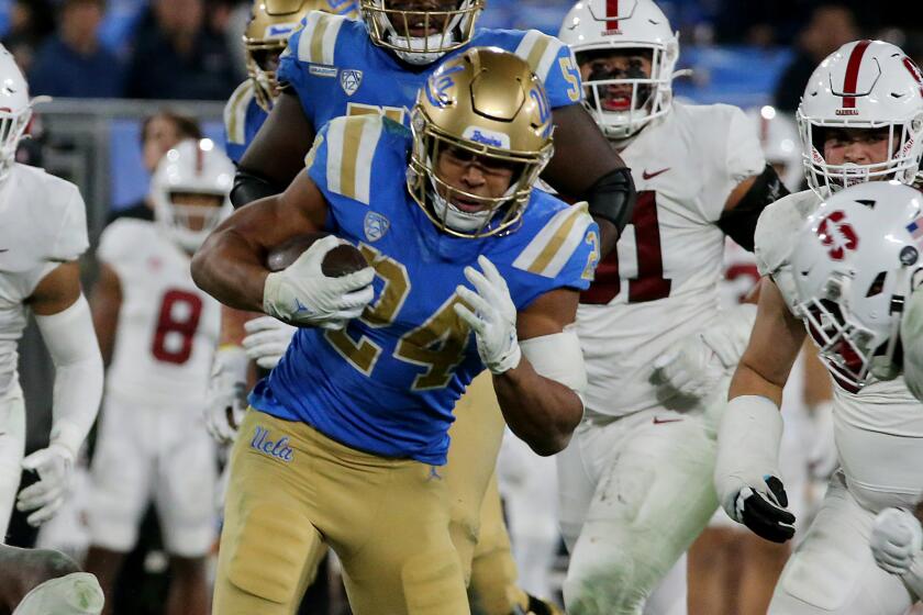 PASADENA, CALIF. - OCT. 29, 2022. UCLA running back Zach. Charbonnet runs over Stanford defenders.