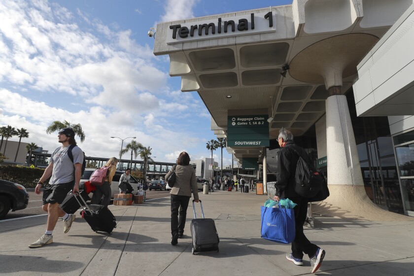 Travelers walk past Terminal 1 at the San Diego International Airport.
