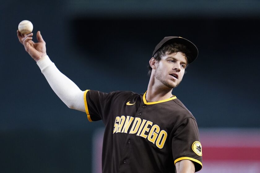 San Diego Padres first baseman Wil Myers flips a ball out of play after warming up during the eighth inning of a baseball game against the Arizona Diamondbacks in Phoenix, Sunday, Sept. 18, 2022. The Padres won 6-1. (AP Photo/Ross D. Franklin)