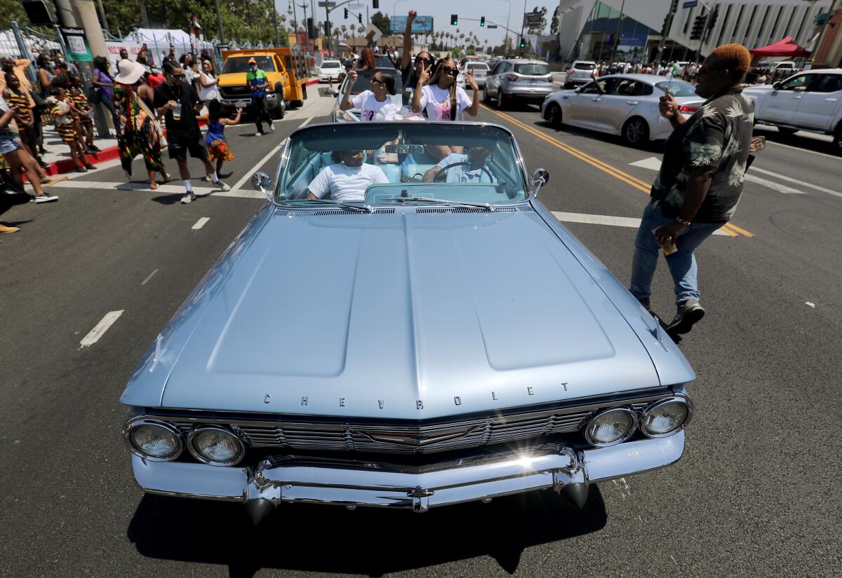 A motorcade of people celebrating Juneteenth makes its way down Crenshaw Boulevard in Leimert Park on Saturday.