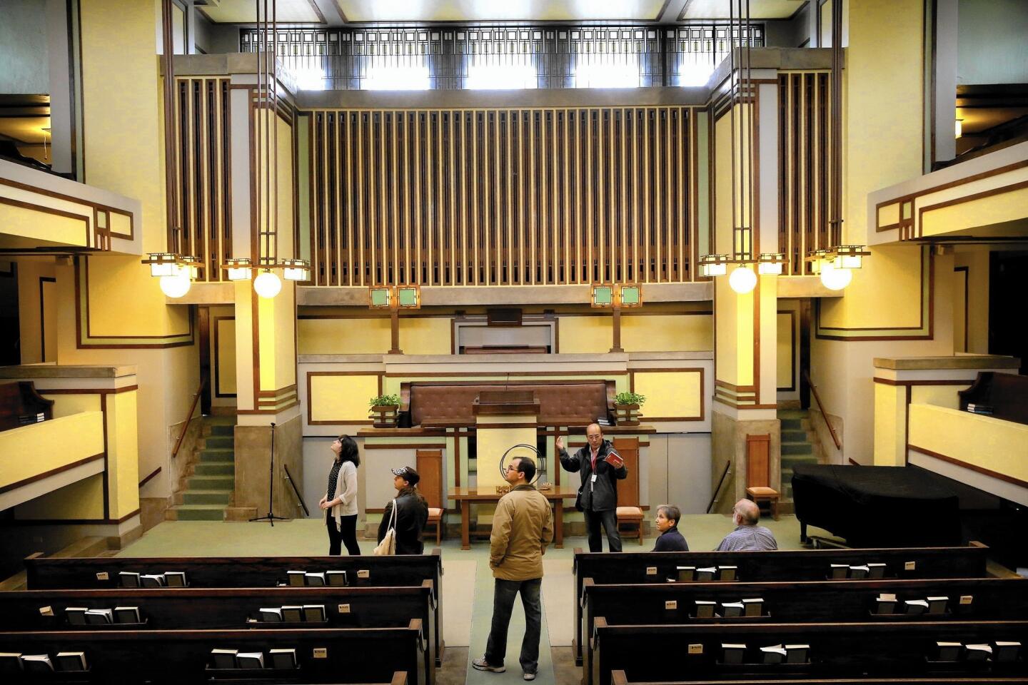 A tour guide explains the architectural wonders inside the sanctuary of Frank Lloyd Wright's Unity Temple before renovations began on the Oak Park building.