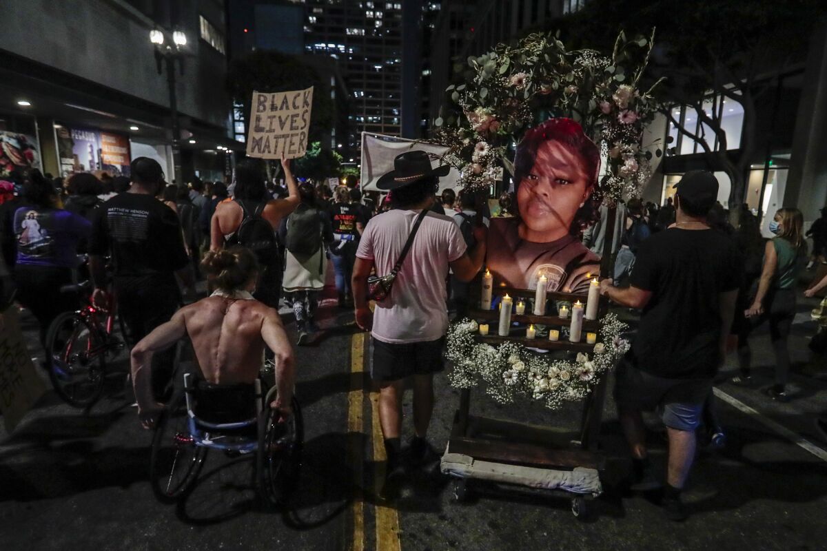 Protesters push along a shrine to Breonna Taylor as hundreds march downtown.