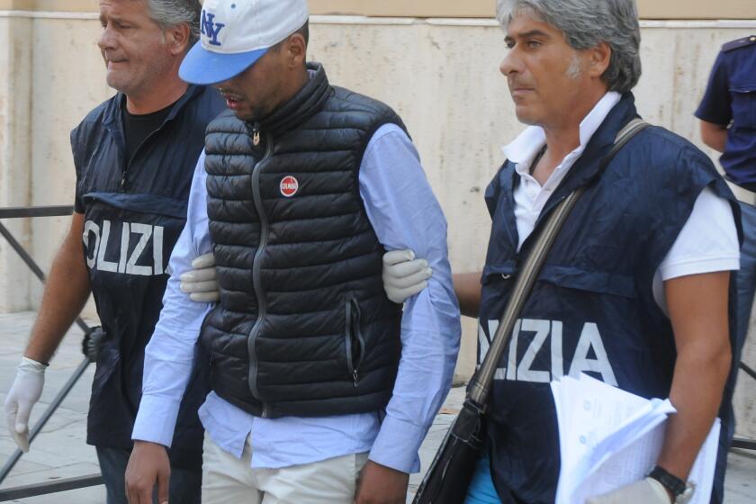 Mourad Botaib is taken to police offices in Palermo, Italy, on Friday. Prosecutors in Sicily detained 10 people on suspicion of smuggling and murder Friday for having allegedly crammed dozens of migrants into the airless hold of a boat where 52 bodies were found this week.