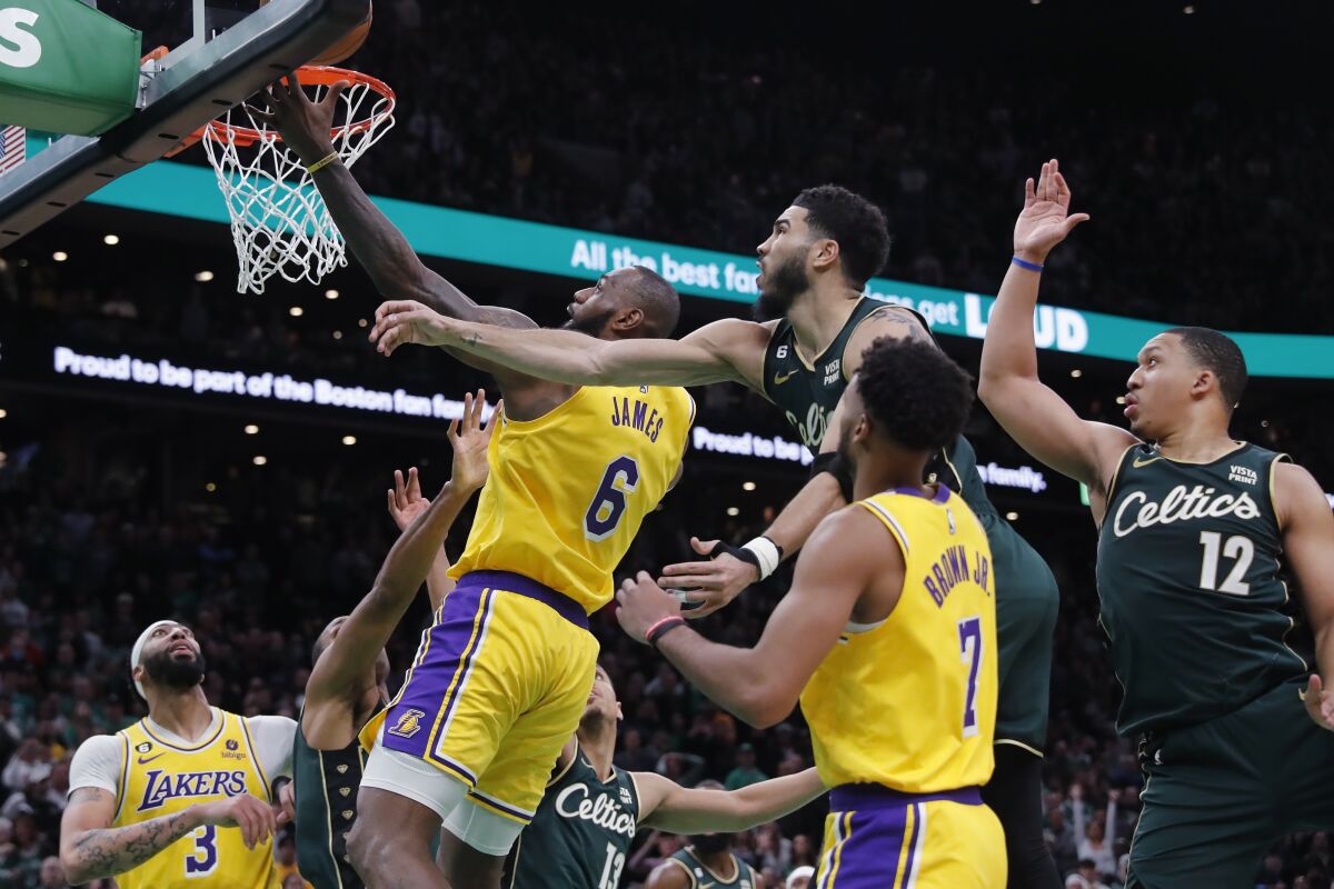 Los Angeles Lakers' LeBron James (6) misses a shot against Boston Celtics' Jayson Tatum, top center, late in the fourth quarter of an NBA basketball game Saturday, Jan. 28, 2023, in Boston. (AP Photo/Michael Dwyer)