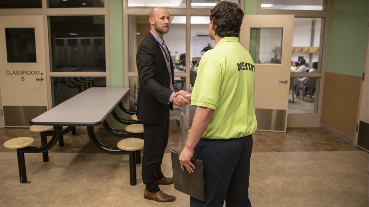 Chief probation officer Lee Seale, left, greets a resident on his way to a leadership class at the Sacramento County Youth Detention Facility.