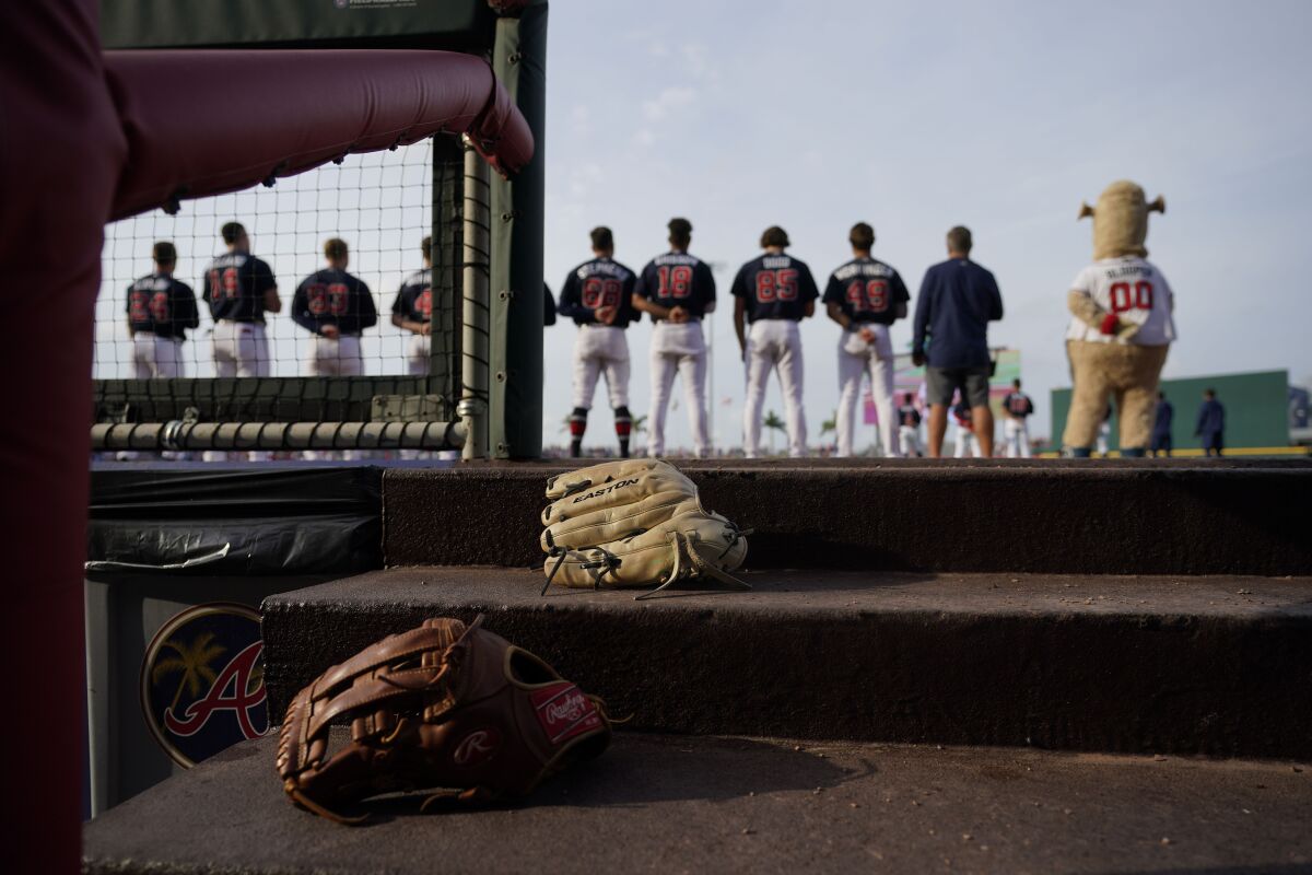 Atlanta Braves line up for the National Anthem before the start of a spring training baseball game against the Philadelphia Phillies in North Port, Fla., Saturday, March 18, 2023. (AP Photo/Gerald Herbert)