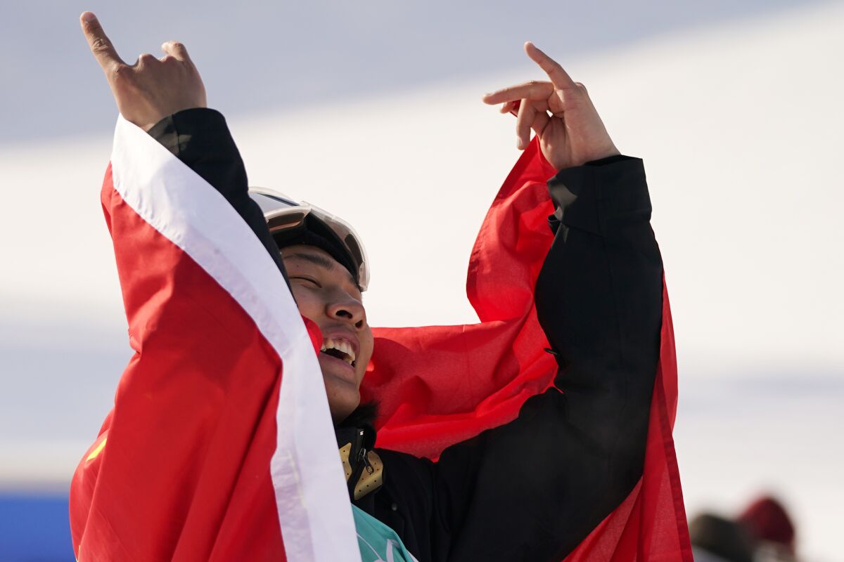Su Yiming of China celebrates his gold medal in the men's snowboard big air finals of the 2022 Winter Olympics, Tuesday, Feb. 15, 2022, in Beijing. (AP Photo/Jae C. Hong)
