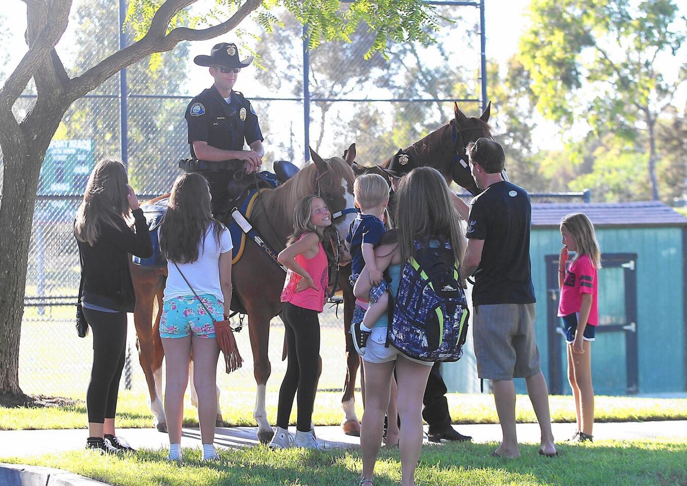 Guests gather around Officer Shawn Dugan and his horse Levi at Tuesday's National Night Out event at Bonita Canyon Sports Park in Newport Beach. The event promotes relationships between police and neighborhoods.