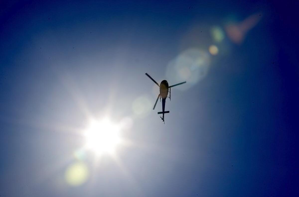 An LAPD helicopter hovers over Crenshaw Boulevard and the 10 Freeway.