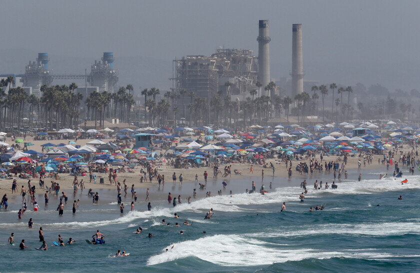A Labor Day weekend crowd descends on Huntington Beach as a heat wave grips Southern California Saturday.