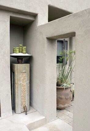 Stone niches showcase a candle stand and water fountain that capture the energetic vibe of the outdoors.
