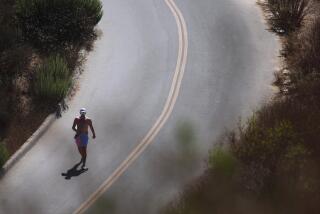 CULVER CITY, CA - AUGUST 7, 2023 - Scott Hall, 38, makes his way along the hot pavement on the road down from the Baldwin Hills Scenic Overlook with temperatures reaching the upper 80s in Culver City on August 7, 2023. "I feel the humidity is starting to pick up in Cali," Hall said about the current weather conditions. (Genaro Molina / Los Angeles Times)