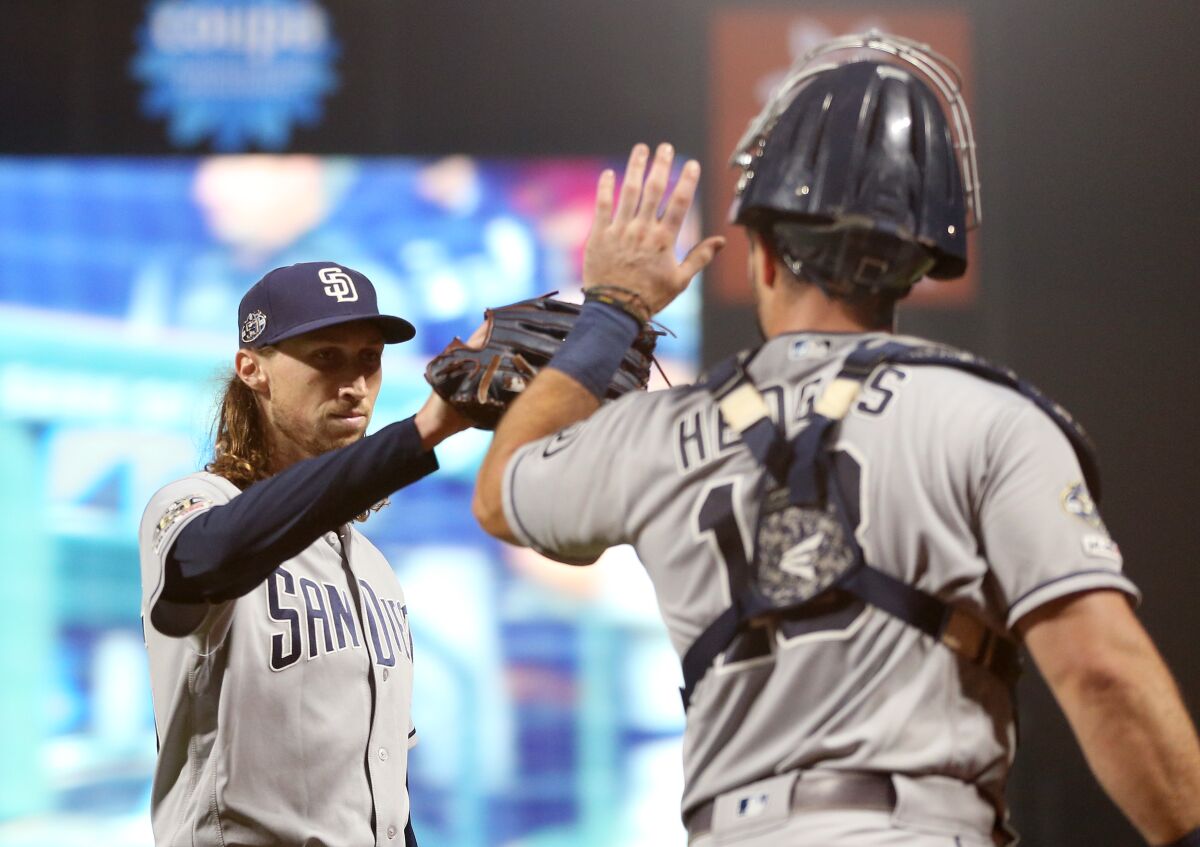 Padres reliever Matt Strahm gets a high-five from catcher Austin Hedges after the eighth inning Thursday against the San Francisco Giants.