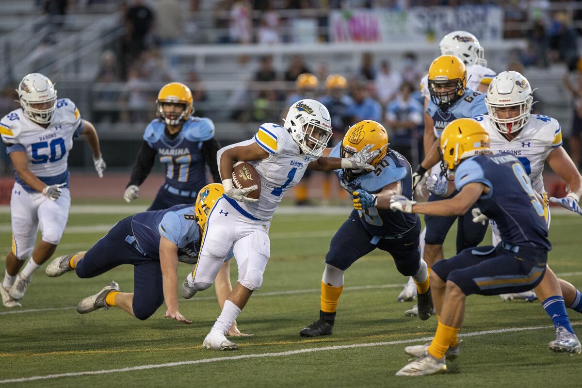 Fountain Valley's Hercules Windrath carries the ball upfield as Marina's Micah Asato attempts a tackle.