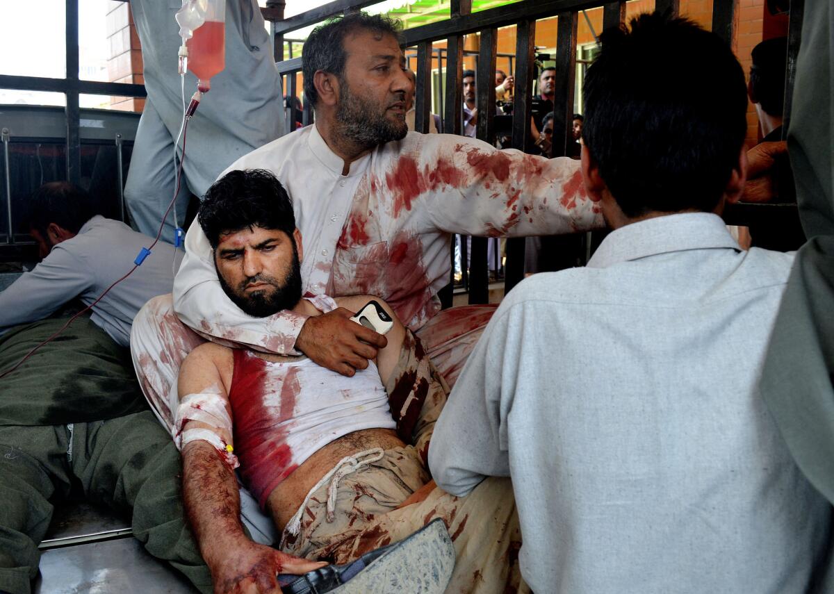 Volunteers carry an injured man to a hospital in Peshawar, Pakistan, on March 7 after a suicide bomber attacked a nearby court complex.