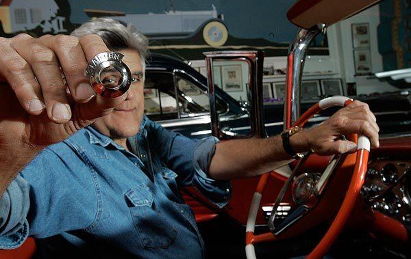 Jay Leno holds a starter switch bezel for the 1956 Packard Caribbean he keeps in his warehouse-sized Burbank garage, which houses his collection of more than 200 cars and motorcycles. A prototype for the hard-to-find auto part was designed and printed in plastic using a 3-D printer.