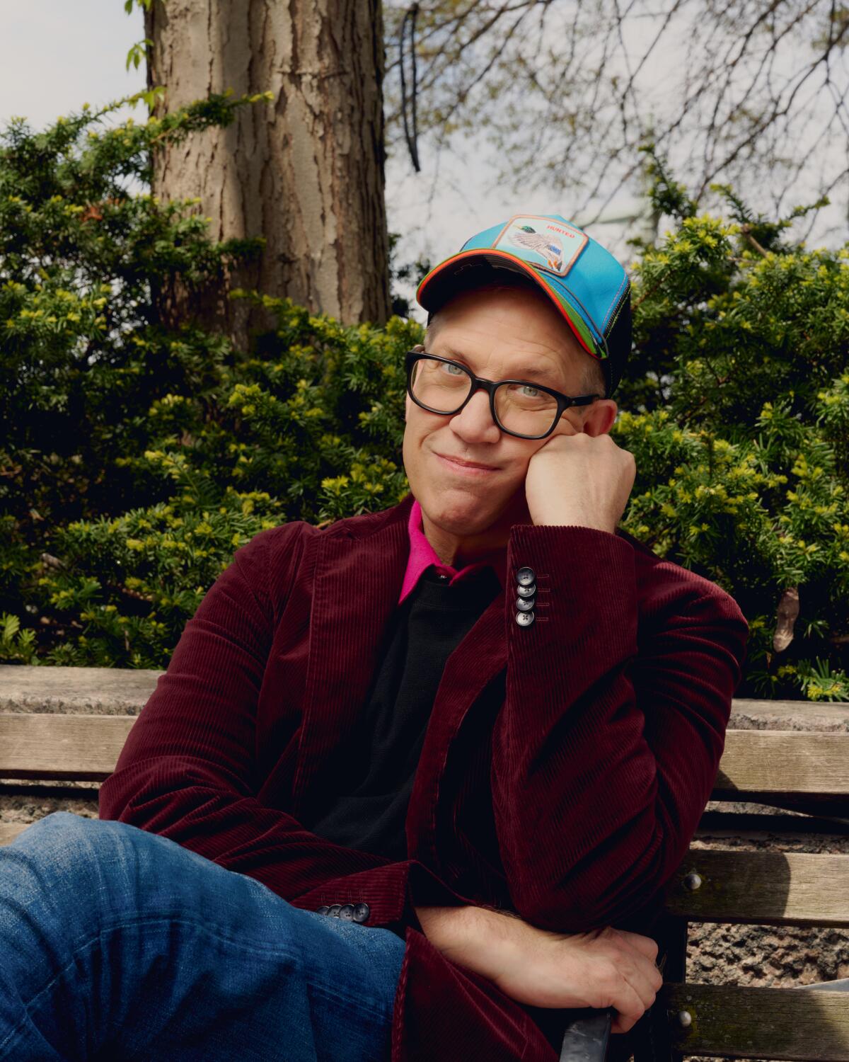 John Hoffman is sitting on a park bench with his head resting on his hand.