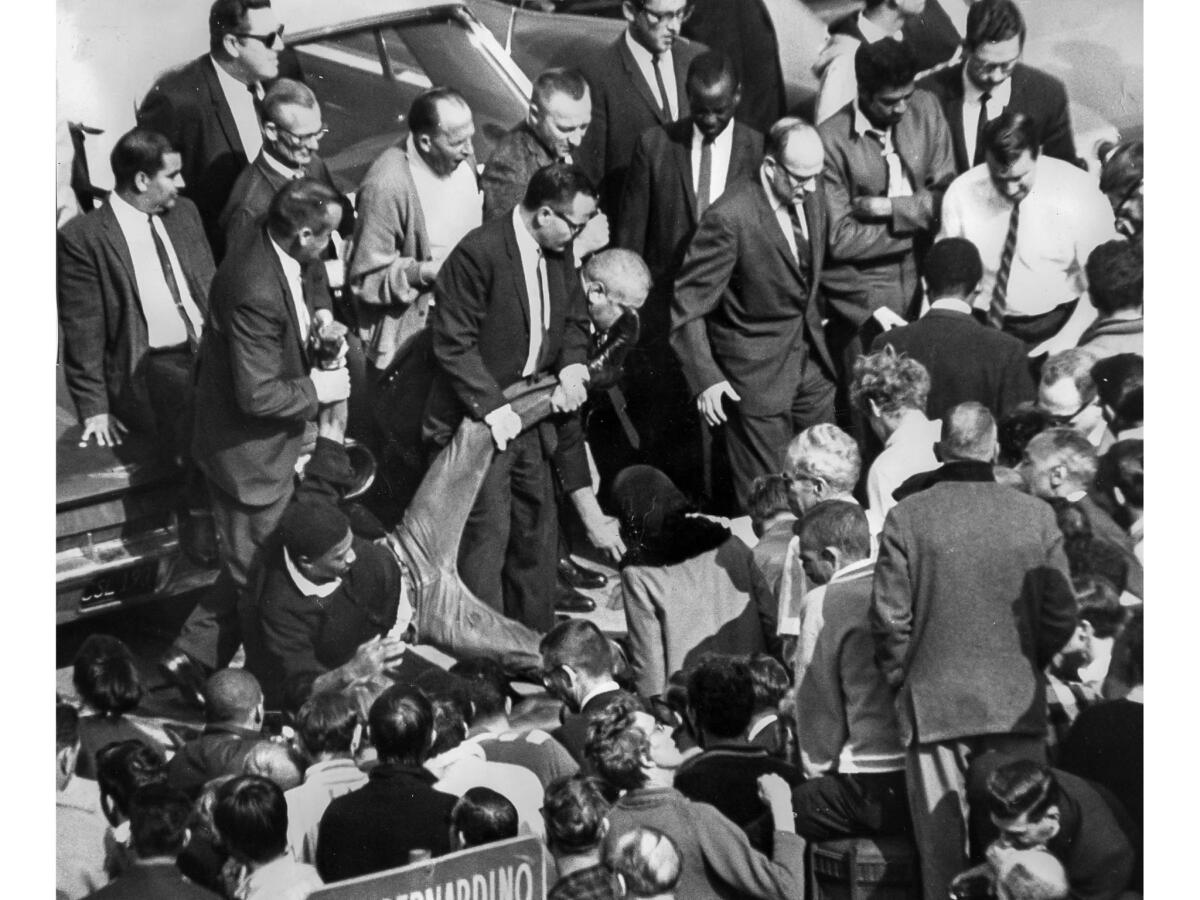 March 10, 1965: A sit-in demonstrator is lifted by his arm and leg as he is removed from a Federal Building parking lot in Los Angeles. Arrests began after the demonstrators blocked the path of a U.S. mail truck.