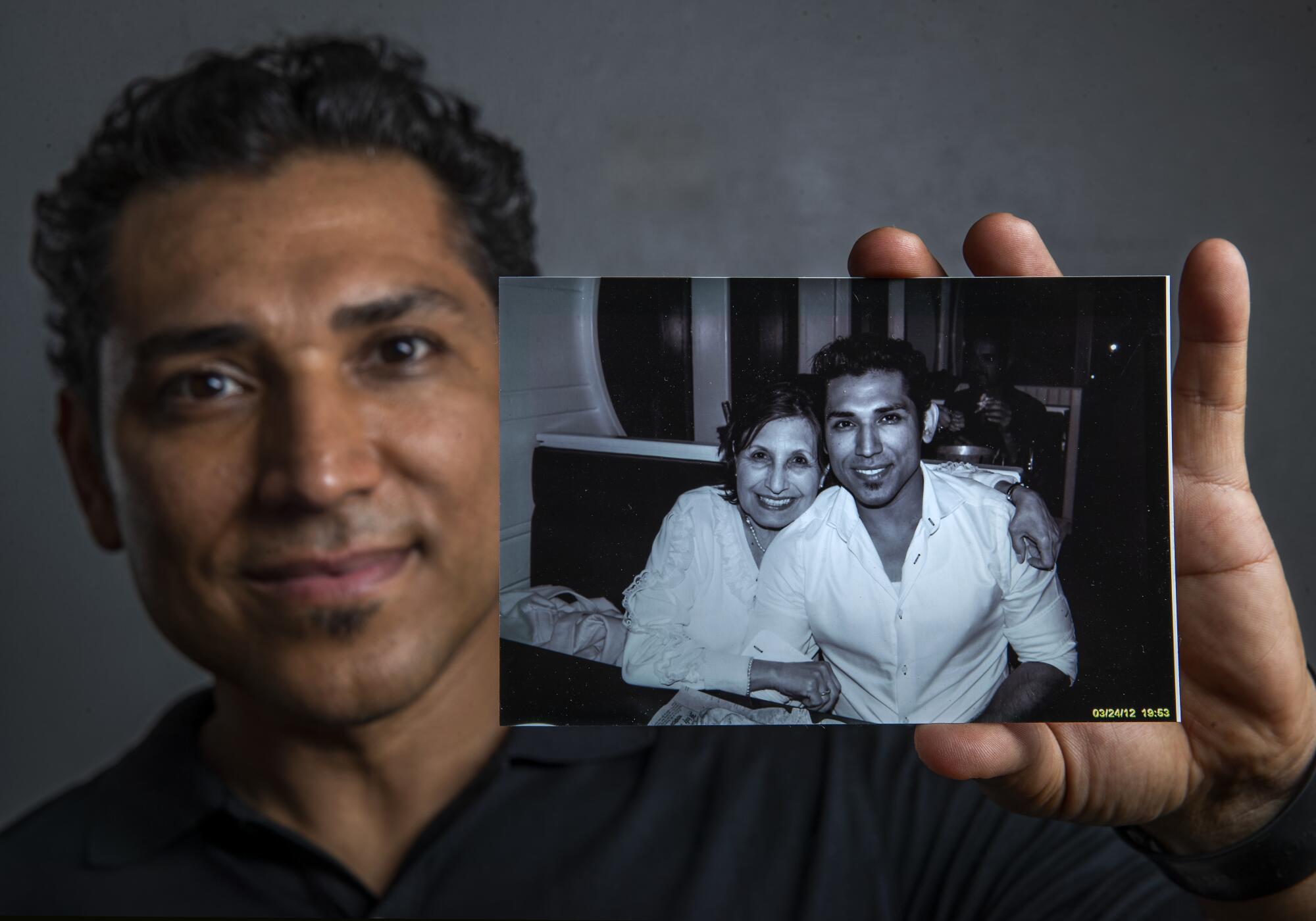 Disney character designer José  Zelaya holds a photograph taken in 2012 of him and his mother, Degni Garcia Menendez. 