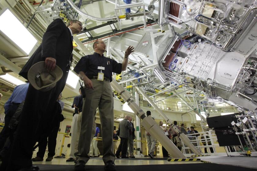 Mark Jackson, center, gives a tour of the target bay of the National Ignition Facility to Stephen Eckstrand, left, of the U.S. Department of Energy at the Lawrence Livermore Laboratory in Livermore , Calif., Friday, May 29, 2009. The football-field-sized facility is designed to focus 192 lasers at a single target the size of a pencil eraser to create a huge release of energy known as fusion ignition. Its primary purpose is to help ensure the reliability of the nation's aging nuclear weapons.The facility is expected to ramp up power in a series of experiments over the next year. (AP Photo/Marcio Jose Sanchez) ORG XMIT: CAMS101