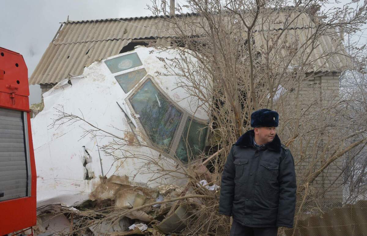 A police officer stands by the wreckage of a Turkish cargo plane at the crash site in the village of Dacha-Suu outside Bishkek on Jan. 16, 2017.