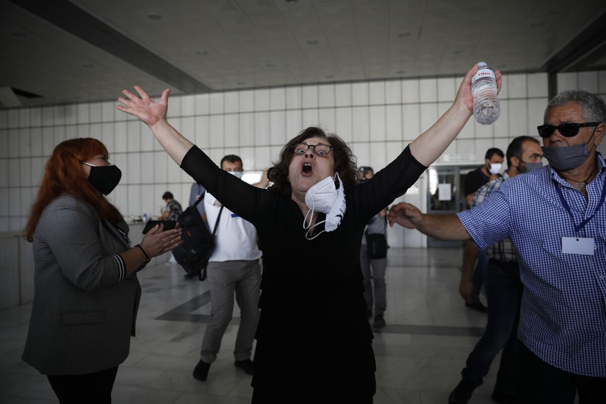 Magda Fyssa, whose son was killed by a Golden Dawn supporter in 2013, throws up her arms in celebration after court ruling