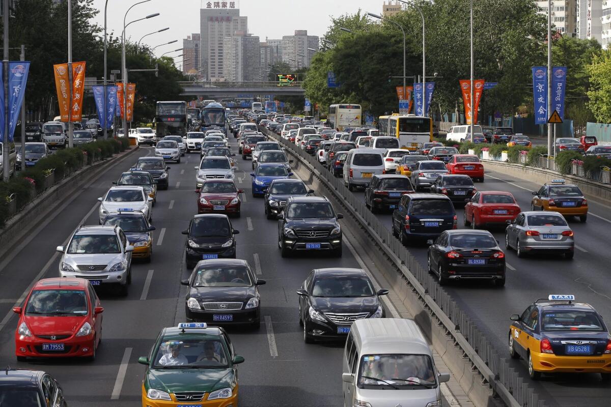 Motorists drive along a main road in Beijing. The Chinese government has offered new incentives for low-emission vehicle sales and said it would require state agencies to increase their purchases of "new energy" vehicles.
