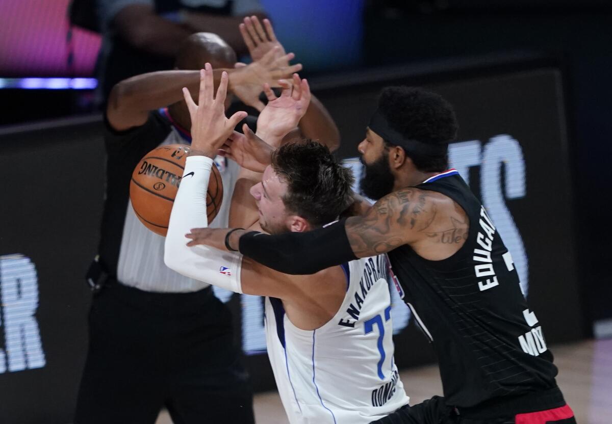 Mavericks forward Luka Doncic (77) is fouled by Clippers forward Marcus Morris Sr. during Game 6 of their playoff series.