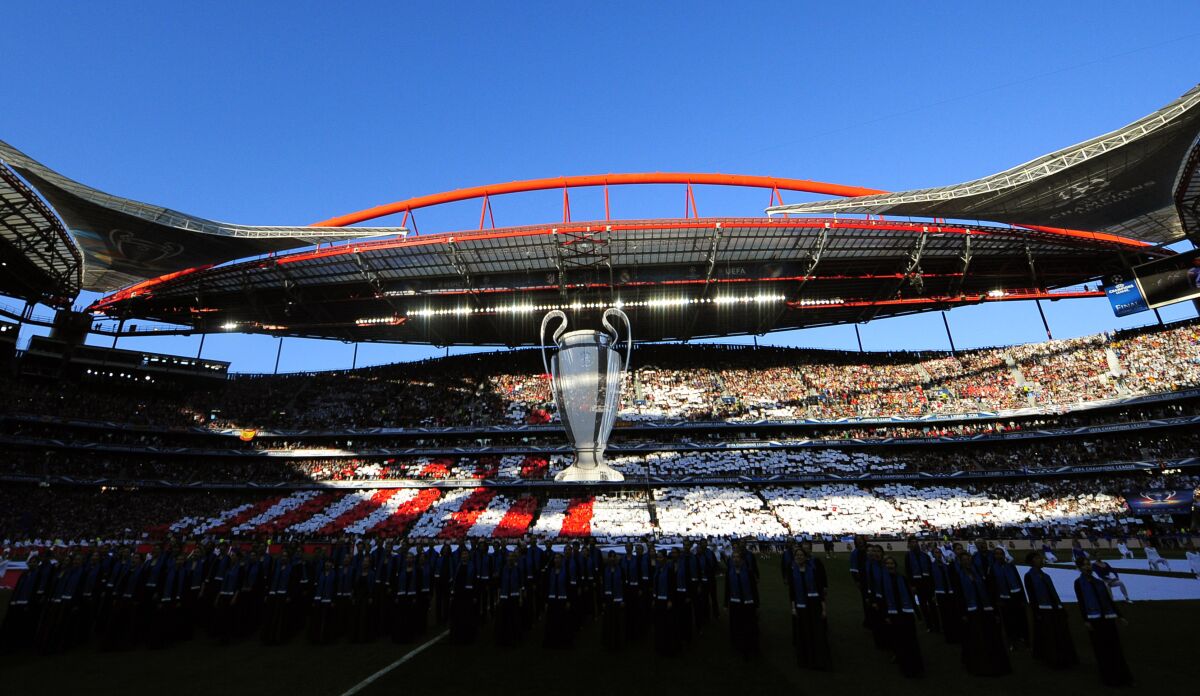 FILE - In this May 24, 2014 file photo, an image of the Champions League trophy is suspended from the roof of the stadium, ahead of the Champions League final soccer match between Atletico Madrid and Real Madrid, at the Luz stadium, in Lisbon, Portugal. UEFA announced Wednesday, June 17, 2020, that the Champions League will finish with a 12-day mini-tournament in Lisbon in August with the final match at the Luz stadium on Aug. 23. (AP Photo/Manu Fernandez)