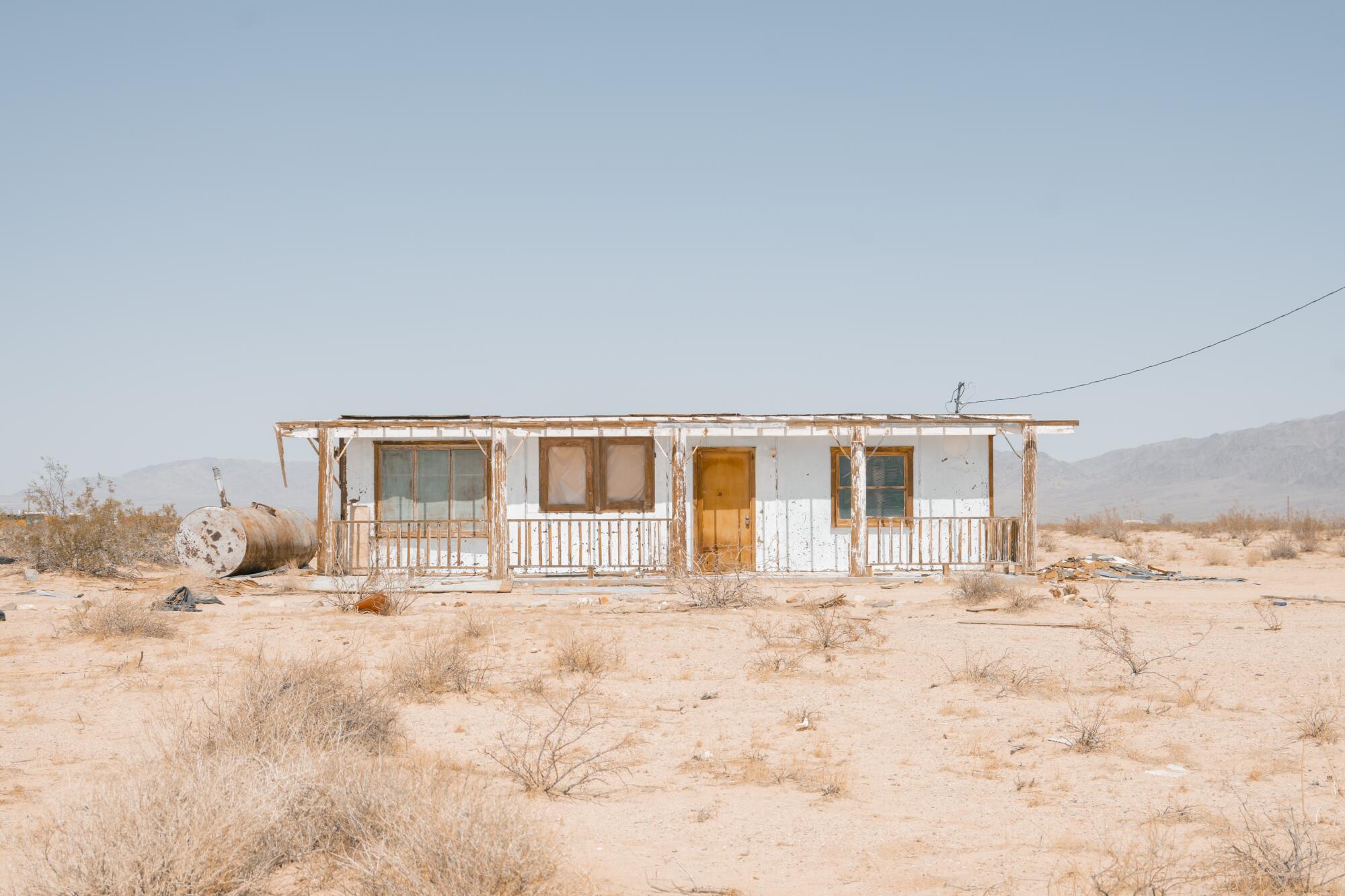 An abandoned boarded up home in the desert.